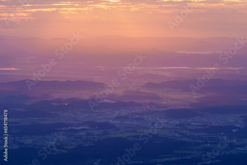 夜明けの朝日の光が降り注ぐ田舎の町と山々　栃木県那須
