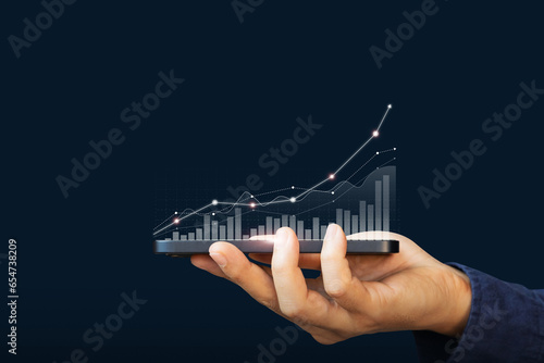 Hand holding smartphone or mobile phone with growth business graph and. Business economic and technology concept