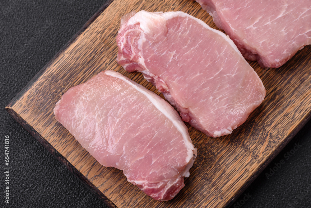 Raw fresh pork meat steak with salt, spices and herbs Raw fresh pork meat steak with salt, spices and herbs