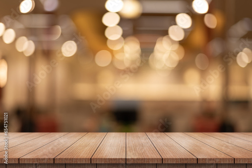 Empty wooden table top with lights bokeh on blur restaurant background.  