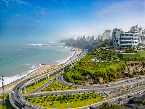 Aerial image of Mirador Arturo Polanco with luxury houses on the stone hillside, large avenue Bajada de Armendariz and Playa La Estrella in the background.