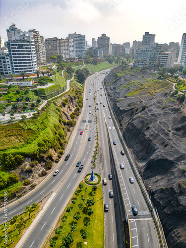 Aerial image of Mirador Arturo Polanco with luxury houses on the stone hillside, large avenue Bajada de Armendariz and Playa La Estrella in the background. photo