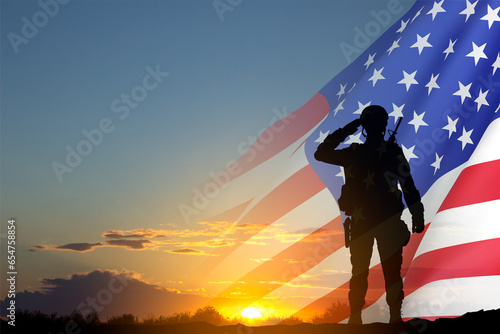Quadro su tela Silhouette of soldier with USA flag against the sunset