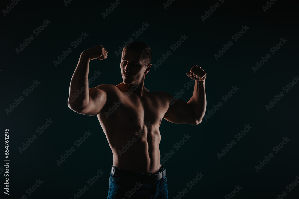 Silhouette photo of strong man showing his biceps and proudly looking at them. Sport motivation concept