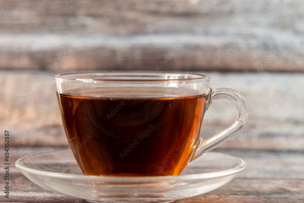 Front shot of black tea placed on wooden texture with defocused background. Front shot of black tea placed on wooden texture with defocused background.