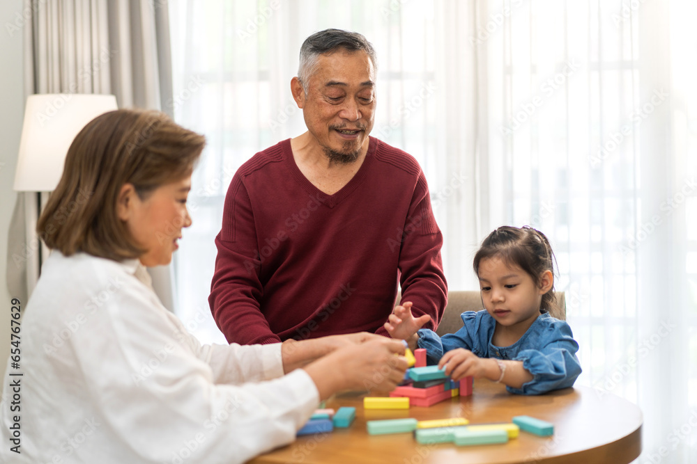 Portrait of happy love asian grandfather with grandmother and asian little cute girl enjoy relax at home.Young girl with their laughing grandparents smiling together.Family and togetherness Portrait of happy love asian grandfather with grandmother and asian little cute girl enjoy relax at home.Young girl with their laughing grandparents smiling together.Family and togetherness