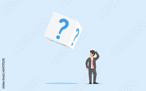 Concept of hesitation. doubt in investment. uncertainty. a confused businessman looking at a dice with a question mark. investment risk that is always haunted by uncertainty. finding the answers.