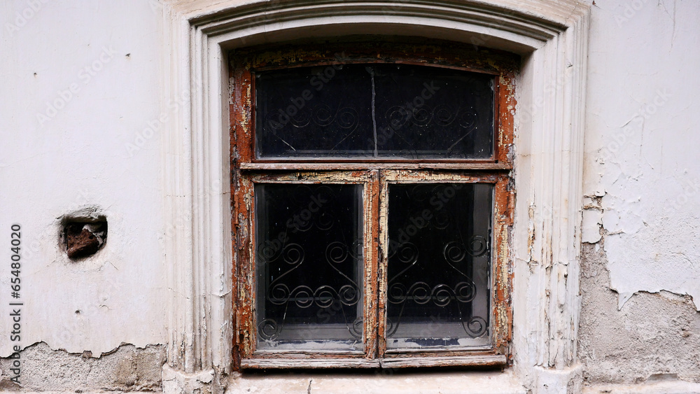 An old dark window. Stock footage. A white old house in which a dark window without light inside is removed in daylight.
