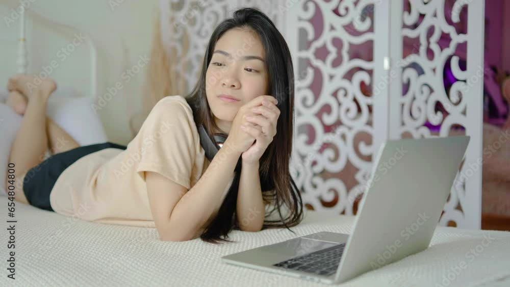 Happy young woman lying on bed, using laptop in the morning. lifestyle and relaxing at home with technology. freelancer working at home. Happy young woman lying on bed, using laptop in the morning. lifestyle and relaxing at home with technology. freelancer working at home.