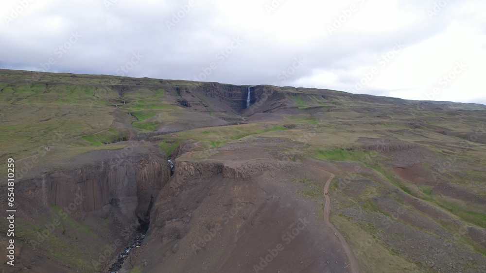 AERIAL VIEW Hengifoss is a waterfall that runs from the river Hengifossá in the municipality of Fljótsdalshreppur in East Iceland. At 128 meters (420 feet) it is the third tallest waterfall in Iceland
