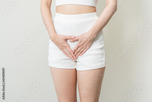 Vaginal, urinary incontinence. Pain asian young woman hand holding crotch suffering from pain, itchy or scratch of vagina, genital itching from infection. Gynecological problems menstrual disorder