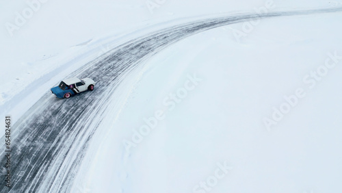 Aerial view of a race car moving fast through the snow desert. Clip. Concept of active lifestyle and sport. © Media Whale Stock
