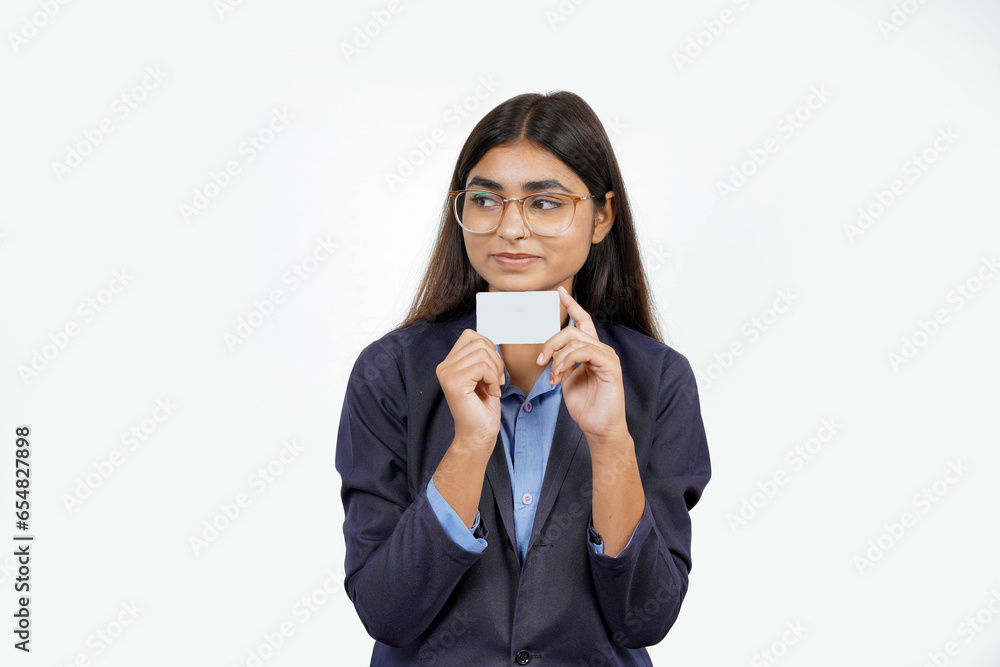 Beautiful young blonde woman holding up a credit card while avoiding her eyes from the copy space in the picture pose. Beautiful young blonde woman holding up a credit card while avoiding her eyes from the copy space in the picture pose.