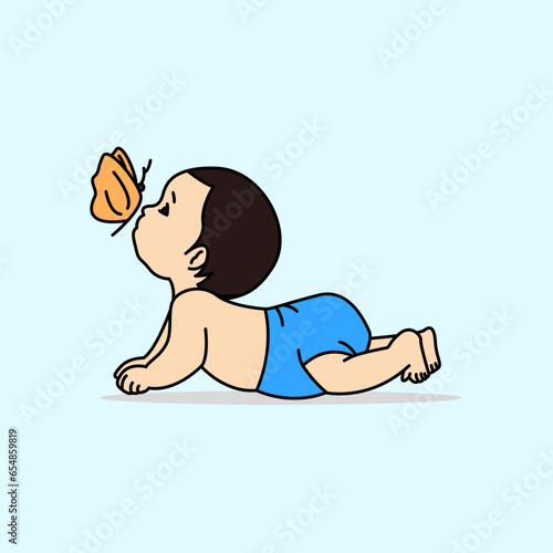 Baby boy playing with butterfly. Baby wearing blue pants.