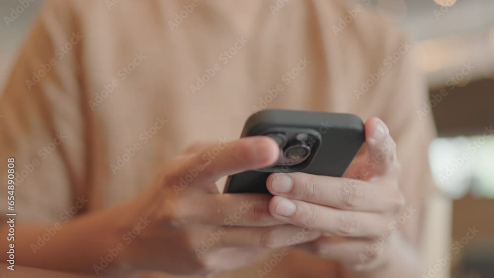 Close-up of a man sitting and typing on a smartphone. Close-up of a man sitting and typing on a smartphone.