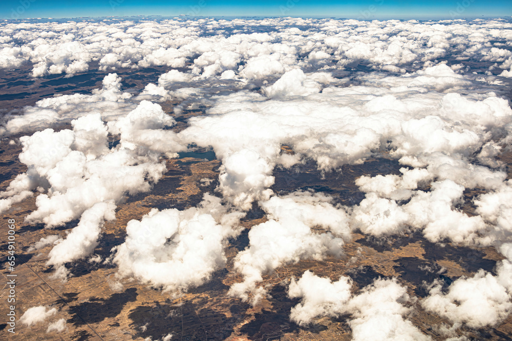 View from 10,000 meters (33,000 feet) of the mountains and arid landscape of western Peru. Dry river paths, dense clouds and no vegetation. View from 10,000 meters (33,000 feet) of the mountains and arid landscape of western Peru. Dry river paths, dense clouds and no vegetation.