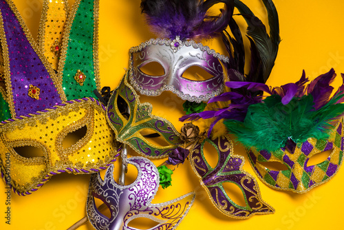 A colorful group of Mardi Gras masks on yellow background