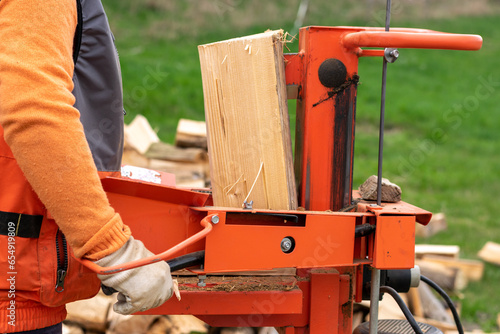 Cuadro en lienzo person splitting firewood on a splitter machine, outdoors