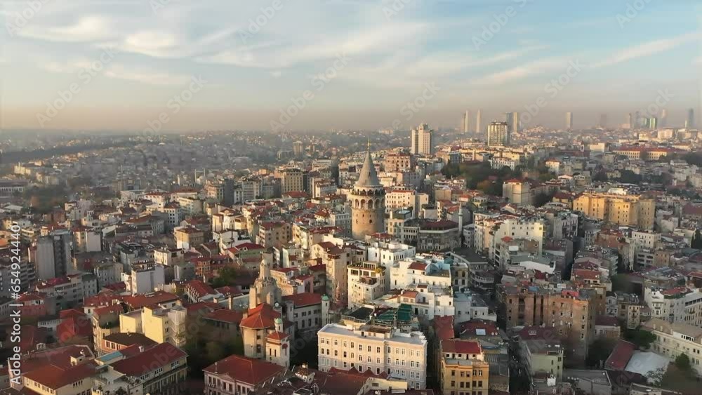 A drone approaches the Galata Tower in Istanbul Beyoglu district at sunset. There are many residences around the tower. Beyoglu, Turkey. A drone approaches the Galata Tower in Istanbul Beyoglu district at sunset. There are many residences around the tower. Beyoglu, Turkey.
