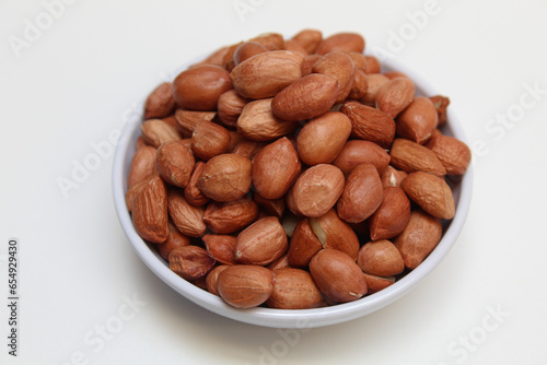 Peanuts or groundnut, or goober, or monkey nut. Peeled peanuts with thin red skin. Isolated on white background