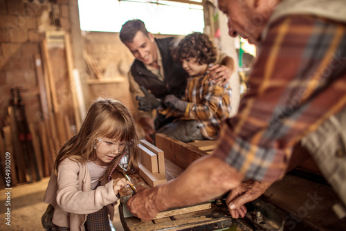 Young future carpenters learning the ways of their elders in a wood shop © Geber86