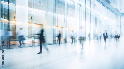 blurred business people walking in glass office background - busy office in a rush hour concept
