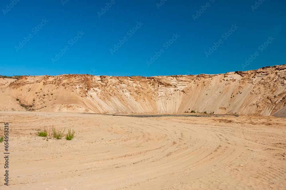 sand pit against the blue sky, forest in the background