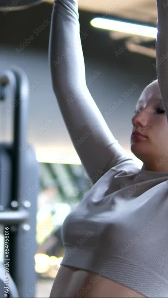young girl in a gray tracksuit gymsuit In a dark gym, dissolve hair ...