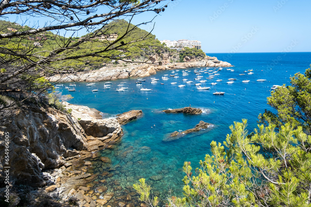 Panoramic view of the Mediterranean Sea in the Costa Brava with tourist boats anchored in the middle.