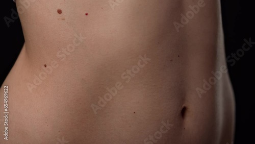 Closeup shot of beautiful caucasian woman body part, tummy and ribs area smooth skin, breathing deeply. photo