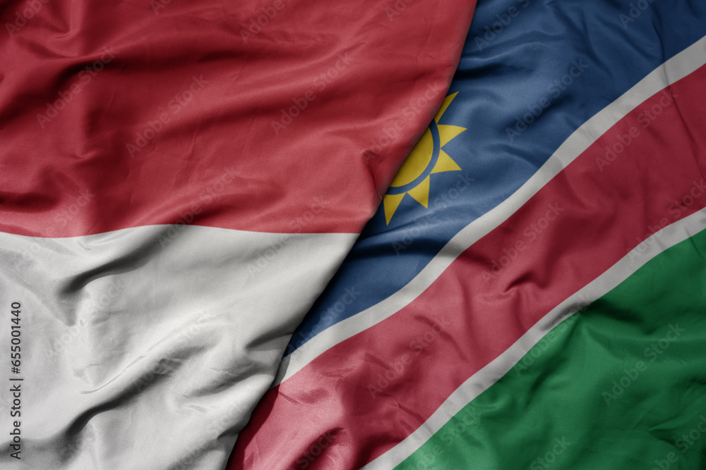 Fototapeta premium big waving realistic national colorful flag of indonesia and national flag of namibia .