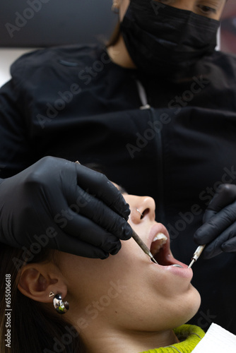 Dental patient with open mouth examined by dentist. Dentist checkup concept.