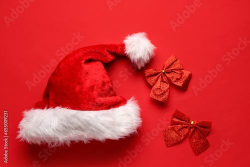 Santa hat with bows on red background © Pixel-Shot