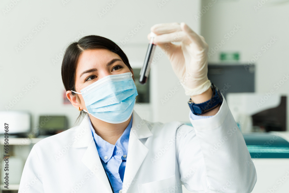 Beautiful chemist doing medical test with blood samples Beautiful chemist doing medical test with blood samples