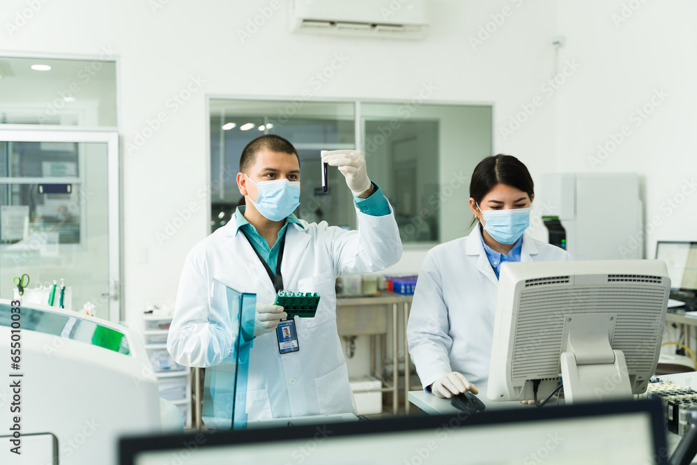 Chemists using blood samples with the lab equipment Chemists using blood samples with the lab equipment