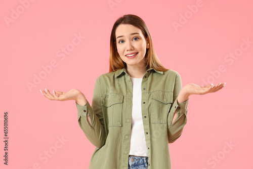 Upset young woman on pink b...