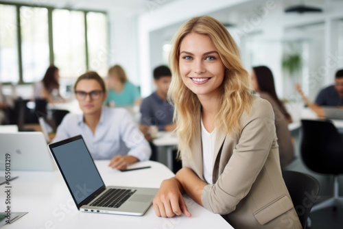 young businesswoman smiling while using her laptop in office