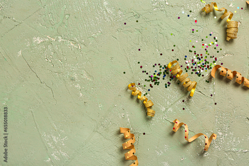 Composition with Christmas ribbons and confetti on green background