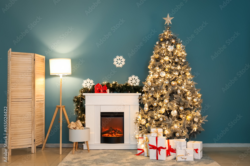 Interior of living room with Christmas tree, glowing lamp and fireplace