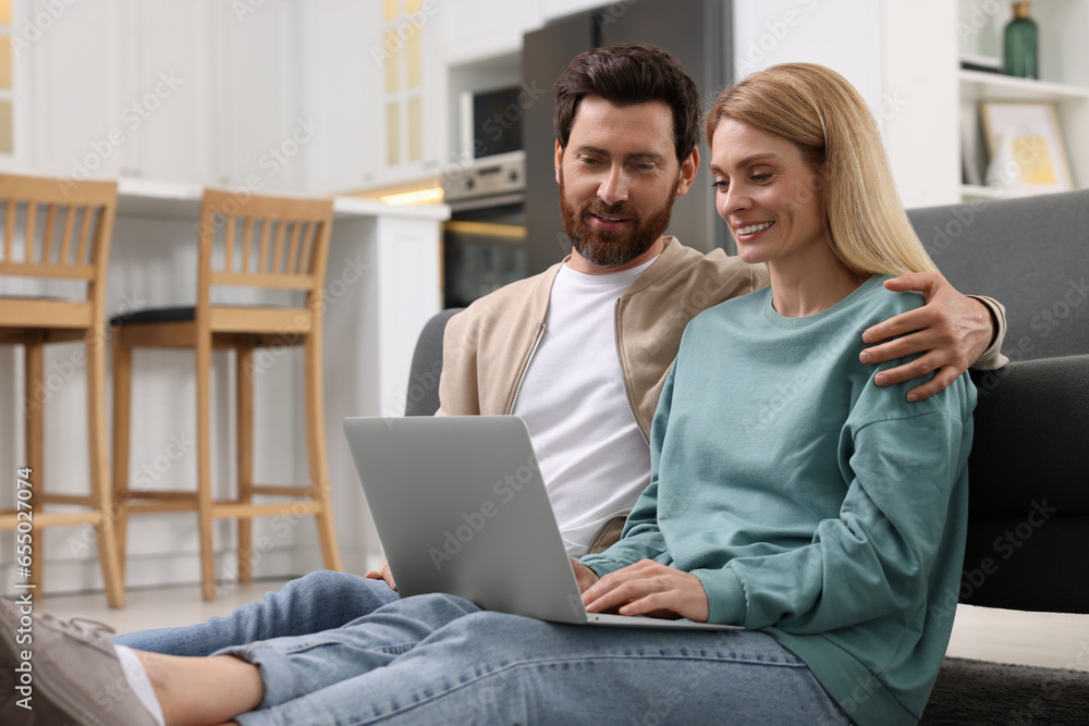 Happy couple spending time together and using laptop at home Happy couple spending time together and using laptop at home