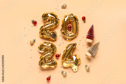 Figure 2024 made of balloons, Christmas decorations and confetti on orange background