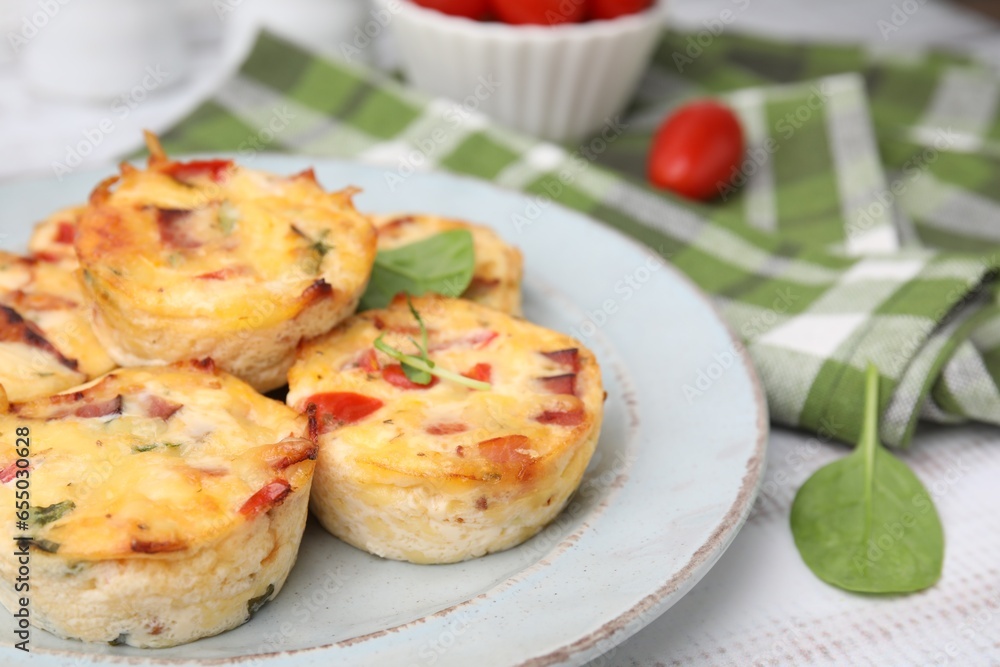 Delicious egg muffins with cheese and bacon on white wooden table, closeup. Space for text