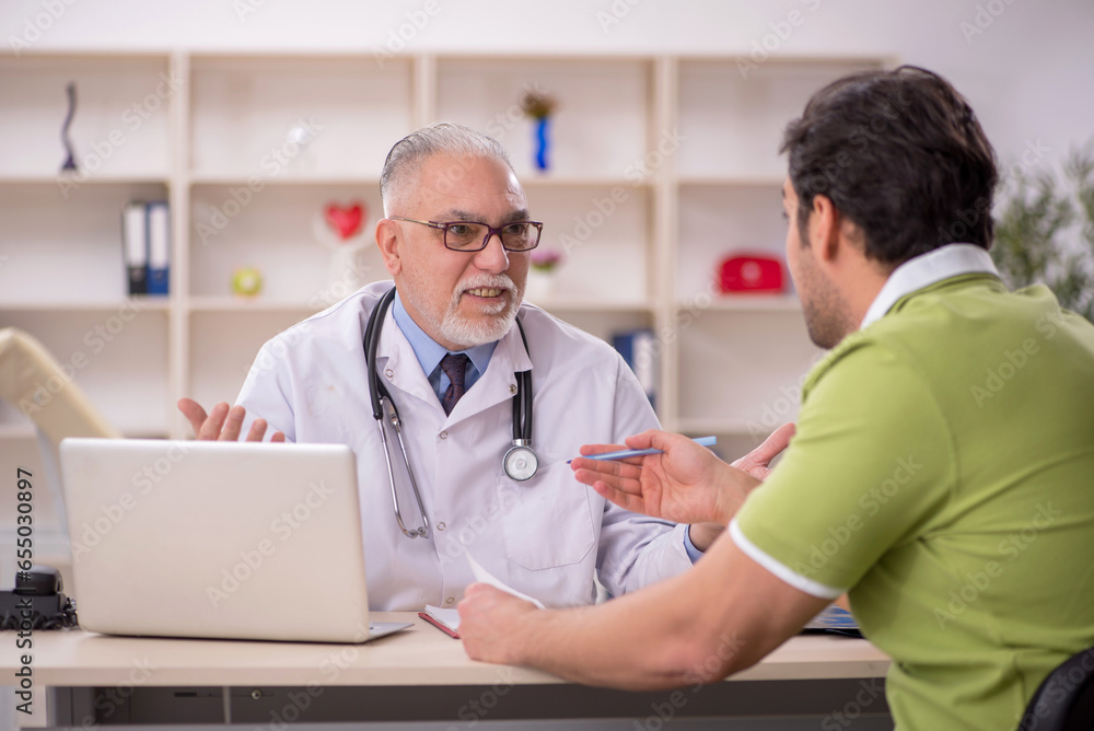 Young male patient visiting old male doctor Young male patient visiting old male doctor