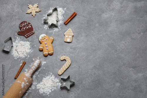 Christmas gingerbread cookies, baking molds and rolling pin on grunge grey background