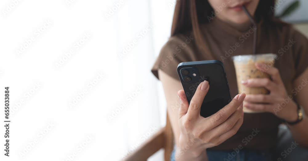 Young asian woman relaxing and using mobile phone, drinking coffee in coffee shop. Casual woman using smartphone for online shopping via mobile app, checking social media, modern people lifestyle Young asian woman relaxing and using mobile phone, drinking coffee in coffee shop. Casual woman using smartphone for online shopping via mobile app, checking social media, modern people lifestyle