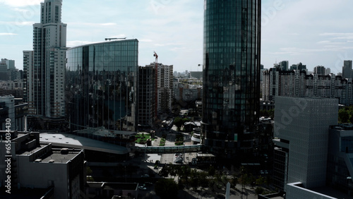 Summer landscape on a built-up city from a height. Stock footage. High-rise beautiful glass offices standing on the banks of the river and green parks for walking and a visible road for traffic. photo