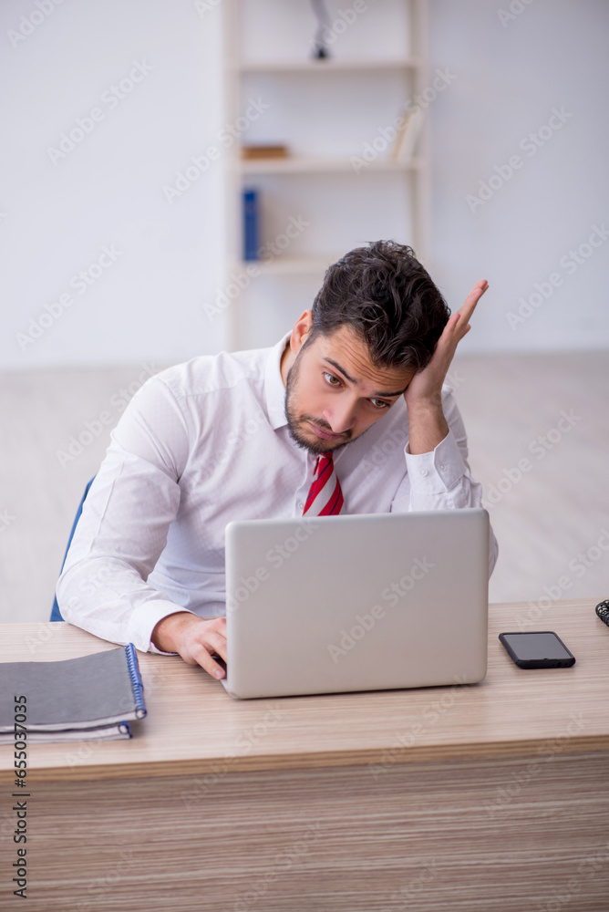 Young male employee working in the office Young male employee working in the office