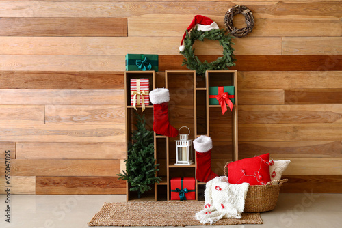Shelving unit with Christmas decor near wooden wall