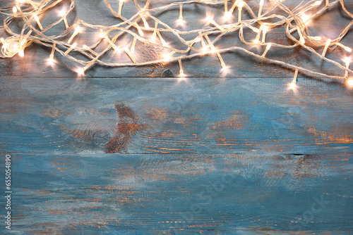 Beautiful Christmas lights on blue wooden background