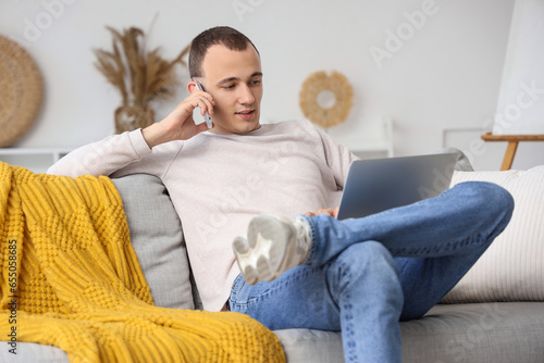 Young man with laptop talki...